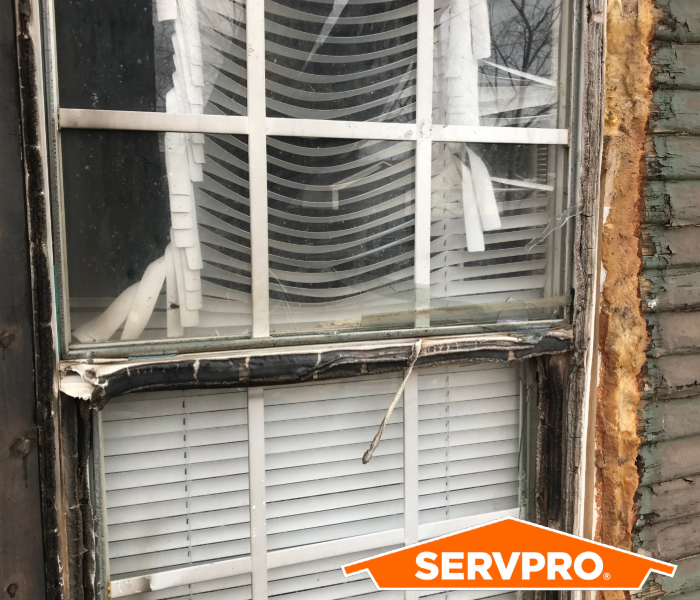 Fire-damaged window with black soot surrounding it. 